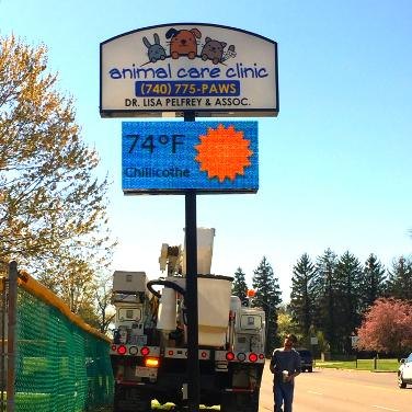 Two Bright Solutions bucket trucks working on the LED message sign at the Animal Care Clinic in Chillicothe